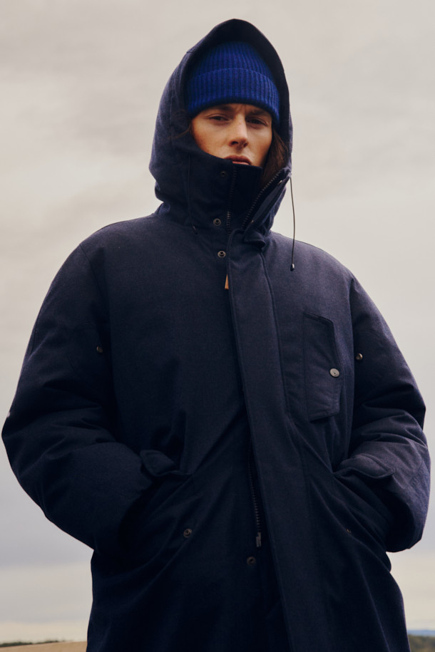 FFC x DOCUMENT(FFC x 도큐먼트) 테크니컬 울 구스다운 파카는 겨울철 데일리룩을 위한 클래식하고 미니멀한 스타일의 아우터입니다. 네이비 컬러의 무지 디자인으로, 울 소재 특유의 부드러운 촉감과 두꺼운 두께감이 특징입니다. 90/10 구스다운 충전재, 라글란 소매, 조절 가능한 스트링, 이중 포켓, 암홀 무 패치 디자인 등 디테일한 요소들이 돋보입니다. 보온, 방풍, 투습 기능을 갖춰 추운 날씨에도 쾌적하게 착용할 수 있습니다. 집업 방식으로 편안하게 여밀 수 있으며, 루즈핏으로 편안한 착용감을 선사합니다.
