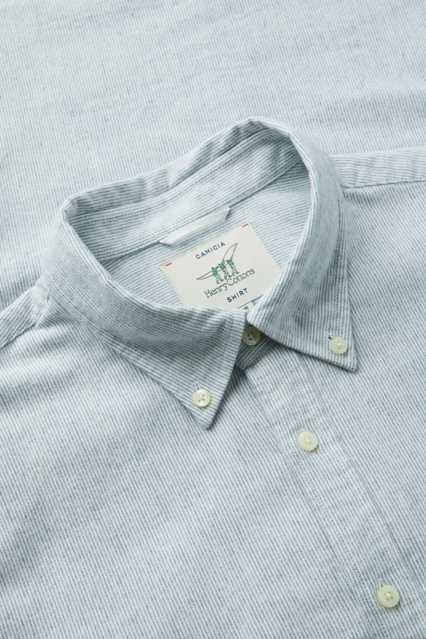 **핀 스트라이프 셔츠 (레귤러핏)**

부드러운 면 기모 옥스포드 원단으로 제작된 핀 스트라이프 셔츠입니다. 화이트와 블루 두 가지 색상으로 출시되었으며, 베이직한 디자인으로 비즈니스 캐주얼 및 일상 룩에 활용하기 좋습니다. 레귤러핏으로 편안한 착용감을 선사하며, 버튼다운 네크라인과 긴 소매 기장이 특징입니다. 가슴 부분에는 로고 자수, 뒷면에는 요크 주름 디테일이 더해져 고급스러운 분위기를 연출합니다. 겨울철 출근룩에 클래식하고 미니멀한 스타일을 더해보세요.
