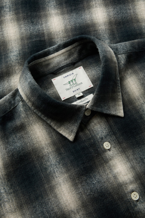 [imported Fabric] 블랙 옴브레 체크 셔츠 (컴포트핏)는 일본 SUNWELL사의 원단을 사용하여 제작된 캐주얼 셔츠입니다. 면 100% 트윌 기모 소재로 부드러운 촉감과 보온성을 제공하며, 겨울철 데일리룩에 적합합니다. 블랙, 아이보리, 그레이 세 가지 색상으로 출시되었으며, 옴브레 체크 패턴이 빈티지한 무드를 더합니다. 가슴 포켓과 뒷면 요크 주름 디테일, 헨리코튼 라벨이 특징이며, 컴포트핏으로 편안하게 착용 가능합니다. 착용 시기는 11월부터 2월까지입니다.
