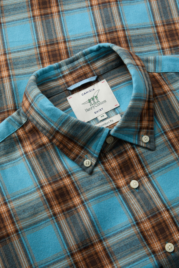 블루와 오렌지, 브라운, 화이트 컬러 배색의 체크 패턴이 돋보이는 셔츠입니다. 부드러운 촉감의 면 100% 트윌 원단으로 제작되어 겨울철에도 따뜻하게 착용할 수 있습니다. 가슴 부분에는 로고 자수 디테일이, 뒷면 요크에는 주름 디테일이 더해져 캐주얼하면서도 클래식한 무드를 연출합니다. 버튼다운 카라와 컴포트 핏으로 제작되어 출근룩이나 비즈니스 캐주얼 스타일에도 활용 가능하며, 미니멀한 스타일을 즐기는 분들께도 추천합니다. 긴 소매 기장으로 다양한 레이어드 연출이 용이합니다.
