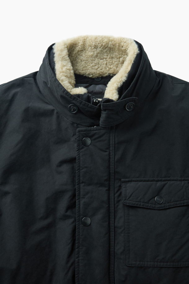 스핏파이어 사파리 다운 점퍼는 겨울철 일상과 출근룩에 모두 잘 어울리는 베이직핏 다운 점퍼입니다. 모던하고 클래식한 스타일의 무지 디자인으로, 허리 엘라스틱 스트링으로 사이즈 조절이 가능합니다. 넉넉한 두께감과 부드러운 촉감의 나일론, 폴리에스테르 혼방 소재로 제작되었으며, 구스다운 충전재를 사용하여 보온성을 높였습니다. 3포켓 구성과 액션 플리츠 디테일, 탈부착 가능한 무통 패널을 갖추어 실용성을 더했습니다. 긴 소매 기장의 사파리 코트 타입으로, 스냅 버튼 여밈 방식을 적용했습니다.
