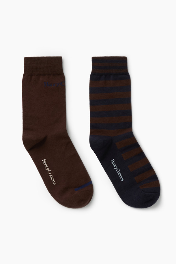 **2족 세트_캐주얼 블럭 양말**

가을, 겨울에 착용하기 좋은 2족 세트 캐주얼 블럭 양말입니다. 면과 스판덱스 혼방 소재로 제작되어 편안한 착용감과 신축성을 제공하며, 발목 부분에는 스판사를 적용하여 흘러내림을 방지합니다. 브라운과 네이비 컬러, 로고 및 스트라이프 패턴의 조화로 클래식하면서도 캐주얼한 스타일을 연출할 수 있습니다. 논슬립 기능과 톤온톤 배색, 실리콘 프린트 디자인으로 포인트를 더했습니다. 겨울 데일리룩, 산책룩, 집콕룩 등 다양한 TPO에 활용해보세요.
