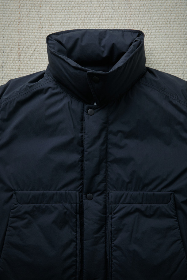 FFC x DOCUMENT (FFC x 도큐먼트) 피셔맨 셔팅 구스 다운 재킷은 겨울철 데일리룩을 위한 미니멀하고 클래식한 스타일의 아우터입니다. 블랙 컬러에 무지 디자인으로 어떤 옷에도 쉽게 매치할 수 있으며, 셔츠형 코트 타입으로 세련된 느낌을 더했습니다. 90/10 구스다운 충전재와 경량 소재를 사용하여 보온성과 편안한 착용감을 제공하며, 루즈핏으로 여유로운 실루엣을 연출합니다. 입체 포켓과 여유있는 어깨라인이 특징이며, 투웨이 지퍼 여밈 방식으로 실용성을 높였습니다.
