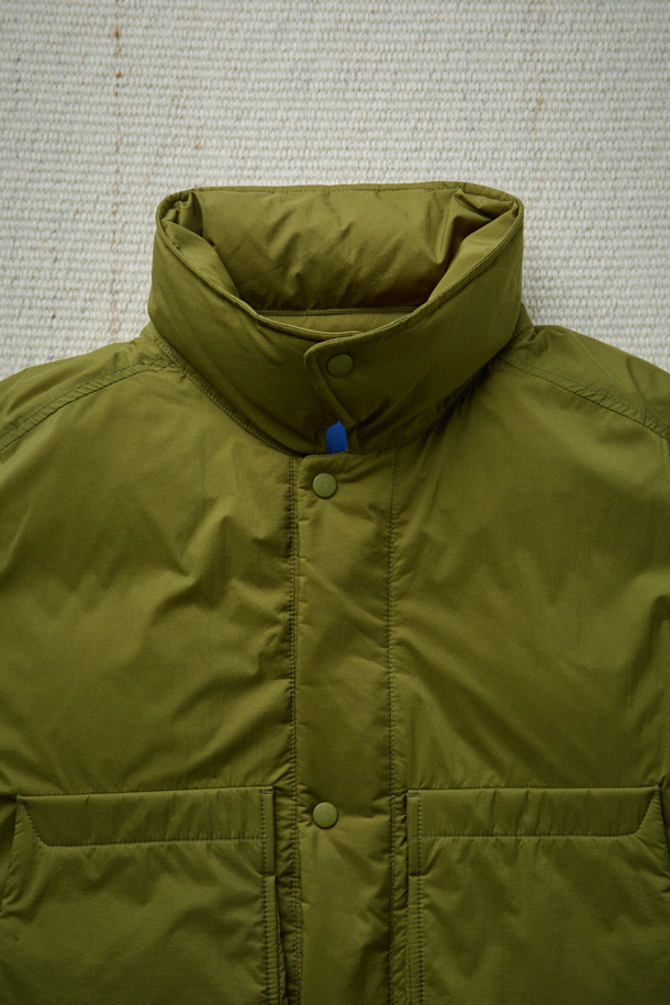 FFC x DOCUMENT (FFC x 도큐먼트) 피셔맨 셔팅 구스 다운 재킷은 겨울철 데일리룩에 적합한 미니멀하면서도 캐주얼한 스타일의 아우터입니다. 올리브 및 카키 색상으로 출시되었으며, 가볍고 따뜻한 구스다운 90/10 충전재를 사용하여 보온성과 경량성을 동시에 잡았습니다. 셔츠형 디자인에 투웨이 지퍼 여밈 방식과 입체 포켓 디테일을 더해 실용성을 높였으며, 여유 있는 어깨 라인과 루즈핏으로 편안한 착용감을 선사합니다. 부드러운 촉감의 나일론 소재로 제작되었으며, 긴 소매 기장과 두꺼운 두께감으로 추운 겨울에도 따뜻하게 입을 수 있습니다.
