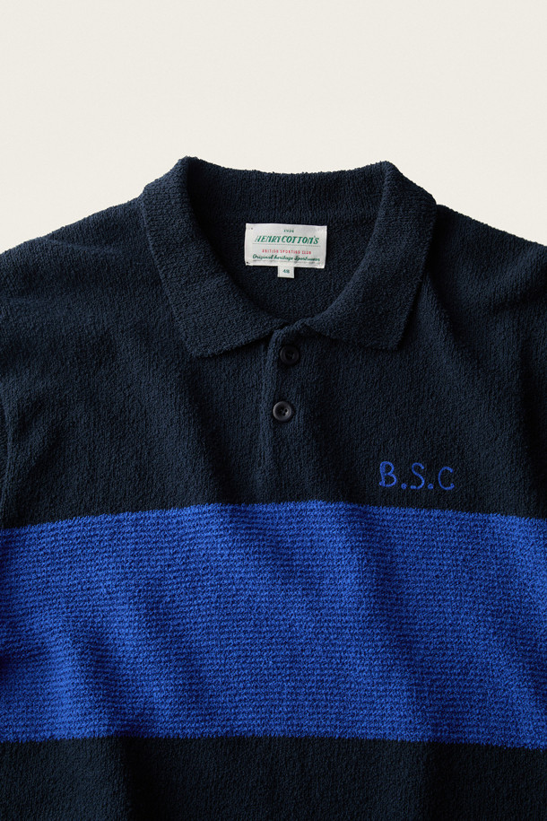 **British Sporting Club 컬러 블록 폴로 니트**

네이비와 블루 컬러 배색이 돋보이는 [British Sporting Club] (브리티시 스포팅 클럽)의 컬러 블록 폴로 니트입니다. 부드러운 촉감의 부클사 니트 소재로 제작되어 가을 시즌에 따뜻하게 착용하기 좋습니다. 루즈핏으로 편안하며, 긴 소매와 폴로넥 디자인이 클래식하면서도 스포티한 무드를 연출합니다. 가슴 부분에는 B.S.C 자수 로고가, 소매와 밑단은 립 조직 마감으로, 단추 여밈 디테일이 돋보입니다. 데이트룩, 카페룩, 가을 나들이룩 등 다양한 스타일링에 활용해 보세요.
