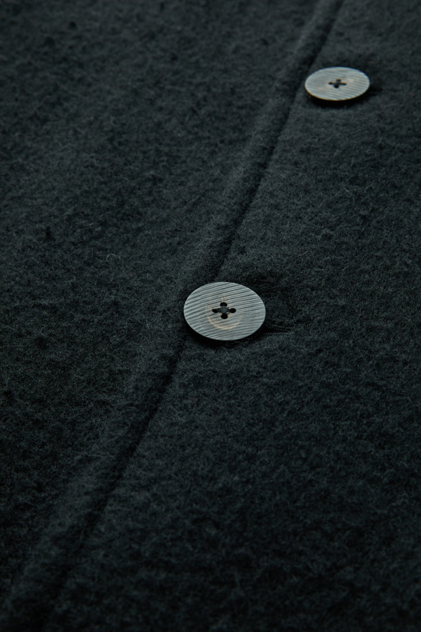 이태리 포르투니 회사 카센티노 원단으로 제작된 울 하프 코트입니다. 겨울철 보온과 방풍 기능을 갖춘 두꺼운 두께감의 릴랙스핏 코트로, 데일리룩과 모임룩에 모두 잘 어울립니다. 베이직한 디자인에 블랙 컬러, 무지 패턴으로 미니멀하고 시크한 스타일을 연출합니다. 드롭숄더와 사선 컷팅 플랩포켓 디테일이 돋보이며, 긴 소매와 버튼 여밈 방식으로 클래식한 매력을 더했습니다.