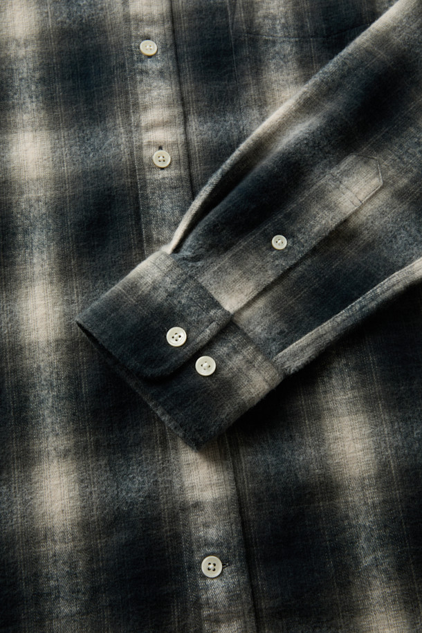 [imported Fabric] 블랙 옴브레 체크 셔츠 (컴포트핏)는 일본 SUNWELL사의 원단을 사용하여 제작된 캐주얼 셔츠입니다. 면 100% 트윌 기모 소재로 부드러운 촉감과 보온성을 제공하며, 겨울철 데일리룩에 적합합니다. 블랙, 아이보리, 그레이 세 가지 색상으로 출시되었으며, 옴브레 체크 패턴이 빈티지한 무드를 더합니다. 가슴 포켓과 뒷면 요크 주름 디테일, 헨리코튼 라벨이 특징이며, 컴포트핏으로 편안하게 착용 가능합니다. 착용 시기는 11월부터 2월까지입니다.
