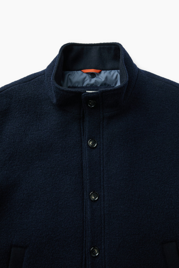 이탈리안 원단으로 제작된 탈착 가능한 후드 울 다운 점퍼입니다. 네이비 컬러의 베이직한 디자인으로, 겨울철 일상, 산책, 여행 등 다양한 TPO에 활용하기 좋습니다. 부드러운 촉감의 울 소재와 구스다운 충전재를 사용하여 보온성과 경량성을 모두 갖췄습니다. 탈착 가능한 후드와 퀼팅 디테일, 울 펠트 배색이 특징이며, 사이드 포켓으로 실용성을 더했습니다. 베이직핏으로 클래식, 미니멀, 캐주얼 스타일을 연출하기에 용이합니다.
