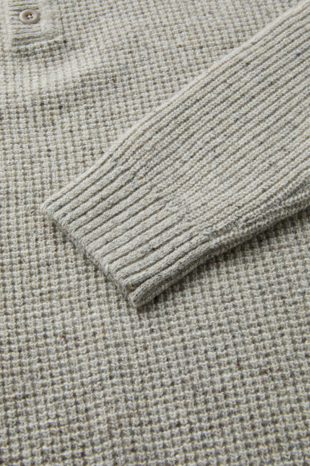 가을, 겨울 시즌에 어울리는 와플 조직 폴로 니트입니다. 부드러운 촉감의 이탈리아 수입 방모 혼방 울 소재를 사용하여 따뜻하고 편안한 착용감을 선사합니다. 루즈핏으로 제작되어 캐주얼한 스타일을 연출하며, 출근룩이나 모임룩으로 활용하기 좋습니다. 세미 와이드 립 조직 카라와 2×2 립 조직 앞단, 네프얀 소재가 디자인의 포인트입니다. 그레이 컬러의 긴소매 폴로넥 디자인으로, 클래식하고 미니멀한 스타일을 즐기기에 좋습니다.