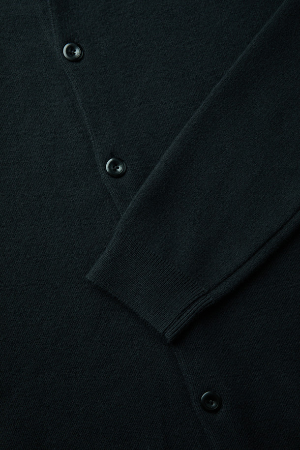 블랙 라운드넥 가디건입니다. 울, 아크릴, 나일론 혼방 소재로 제작되어 부드러운 촉감과 함께 중간 두께감으로 가을, 겨울에 따뜻하게 착용하기 좋습니다. 루즈핏 디자인에 긴소매로 편안한 착용감을 선사하며, 베이직하고 클래식한 스타일로 다양한 룩에 활용하기 좋습니다. 간절기에는 단독으로, 겨울에는 이너로 레이어드하여 세련된 데일리룩, 출근룩, 모임룩을 연출해보세요. 착용 시기는 9월부터 2월까지입니다.
