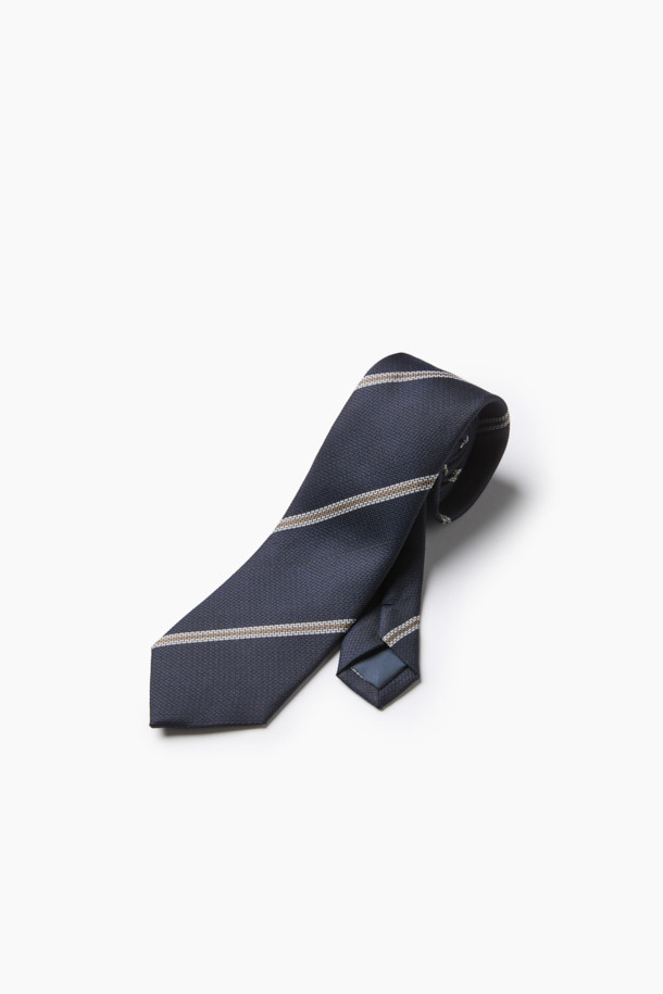 네이비 레지멘탈 타이는 남성용 넥타이로, 가을과 겨울에 착용하기 좋은 아이템입니다. 네이비, 브라운, 화이트 컬러가 조화롭게 어우러진 스트라이프 패턴의 레지멘탈 디자인이 특징이며, 클래식한 분위기를 연출합니다. 실크와 폴리에스테르 혼방 소재로 제작되어 은은한 광택과 부드러운 매끄러운 촉감을 선사하며, 8cm 너비로 제작되었습니다. 내구성이 뛰어나고 관리가 용이하며, 네트 조직감과 입체감 있는 표면으로 고급스러움을 더해 오피스룩, 비즈니스 캐주얼, 회의룩 등 다양한 TPO에 활용하기 좋습니다.
