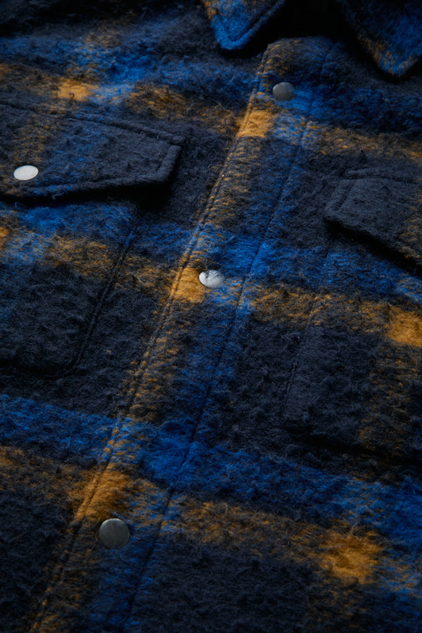 [Fly Fishing Club] 카젠티노 피싱 셔츠는 가을, 겨울에 어울리는 남성용 셔츠형 아우터입니다. 네이비, 로열블루, 오렌지 세 가지 색상으로 출시되었으며, 빈티지, 아웃도어, 워크웨어 스타일을 아우르는 매력을 지닙니다. 울 소재에 두꺼운 두께감과 부클 촉감을 더해 보온성을 높였으며, 긴 소매와 세미 루즈핏으로 편안한 착용감을 선사합니다. 체크 패턴과 체스트 포켓, 사선 핸드 포켓, D-링 디테일, 코듀로이 포켓 배색 등의 특징이 돋보이며, 스냅 여밈 방식과 생활 발수 기능으로 실용성을 더했습니다. 캠핑룩, 가을 나들이룩, 겨울 데일리룩 등 다양한 TPO에 워크웨어, 클래식, 캐주얼 무드로 활용하기 좋습니다.
