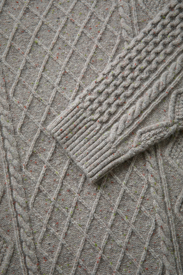 [Fly Fishing Club] 아란 스웨터는 아일랜드 아란 제도의 전통 니팅 스타일을 현대적으로 재해석한 제품입니다. 울과 나일론 혼방 소재로 제작되어 가을, 겨울에 따뜻하게 착용할 수 있으며, 루즈핏 레귤러 기장으로 편안한 착용감을 선사합니다. 입체적인 케이블 및 다이아몬드 무늬와 벌집 조직이 돋보이며, 울 네프 원사를 사용하여 빈티지하면서도 클래식한 분위기를 연출합니다. 립 조직 네크라인과 긴 소매 디자인으로 보온성을 높였으며, 10월부터 2월까지 겨울 데일리룩, 카페룩, 모임룩 등 다양한 스타일에 활용 가능합니다. 가슴둘레 122cm로 넉넉한 핏을 제공합니다.
