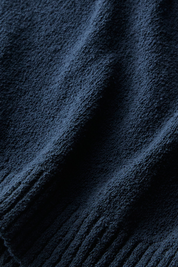 **British Sporting Club 컬러 블록 폴로 니트**

네이비와 블루 컬러 배색이 돋보이는 [British Sporting Club] (브리티시 스포팅 클럽)의 컬러 블록 폴로 니트입니다. 부드러운 촉감의 부클사 니트 소재로 제작되어 가을 시즌에 따뜻하게 착용하기 좋습니다. 루즈핏으로 편안하며, 긴 소매와 폴로넥 디자인이 클래식하면서도 스포티한 무드를 연출합니다. 가슴 부분에는 B.S.C 자수 로고가, 소매와 밑단은 립 조직 마감으로, 단추 여밈 디테일이 돋보입니다. 데이트룩, 카페룩, 가을 나들이룩 등 다양한 스타일링에 활용해 보세요.
