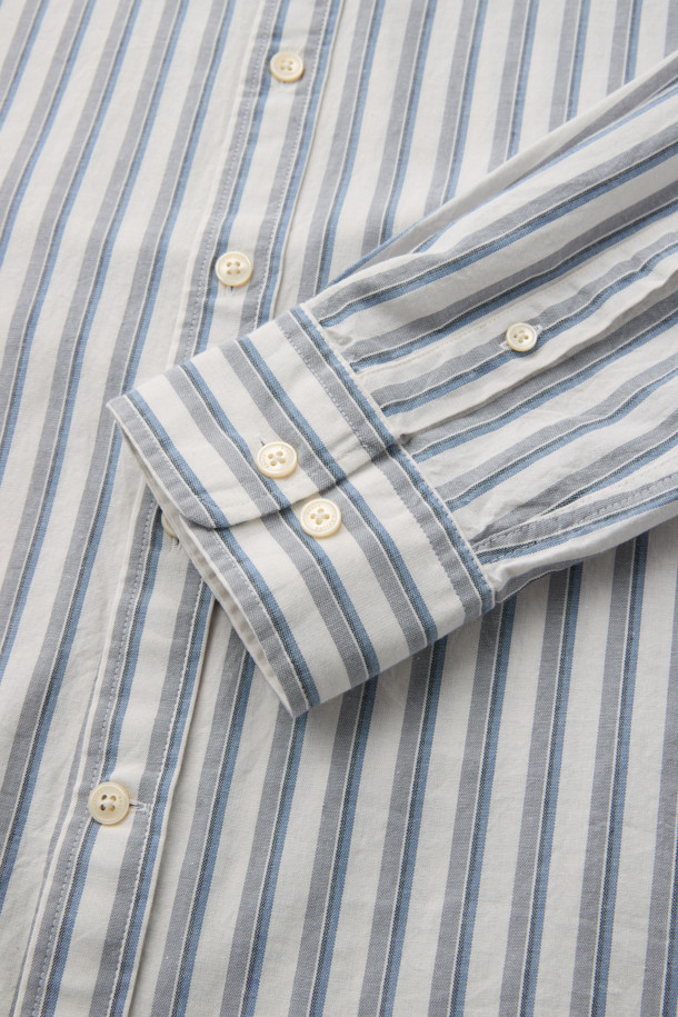 포르투갈 TMG사 원단의 [Imported Fabric] 아이보리 스트라이프 셔츠입니다. 부드러운 코튼 100% 소재로 제작되어 빈티지한 촉감을 선사하며, 가을 시즌 비즈니스 캐주얼 및 출근룩에 적합합니다. 레귤러핏으로 편안한 착용감을 제공하며, 버튼다운칼라와 긴소매 디자인으로 세련된 스타일을 연출합니다. 가슴 로고 자수와 뒷면 요크 주름 디테일이 돋보이며, 캐주얼부터 클래식, 미니멀 스타일까지 폭넓게 소화 가능합니다.
