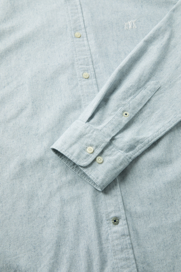 **핀 스트라이프 셔츠 (레귤러핏)**

부드러운 면 기모 옥스포드 원단으로 제작된 핀 스트라이프 셔츠입니다. 화이트와 블루 두 가지 색상으로 출시되었으며, 베이직한 디자인으로 비즈니스 캐주얼 및 일상 룩에 활용하기 좋습니다. 레귤러핏으로 편안한 착용감을 선사하며, 버튼다운 네크라인과 긴 소매 기장이 특징입니다. 가슴 부분에는 로고 자수, 뒷면에는 요크 주름 디테일이 더해져 고급스러운 분위기를 연출합니다. 겨울철 출근룩에 클래식하고 미니멀한 스타일을 더해보세요.
