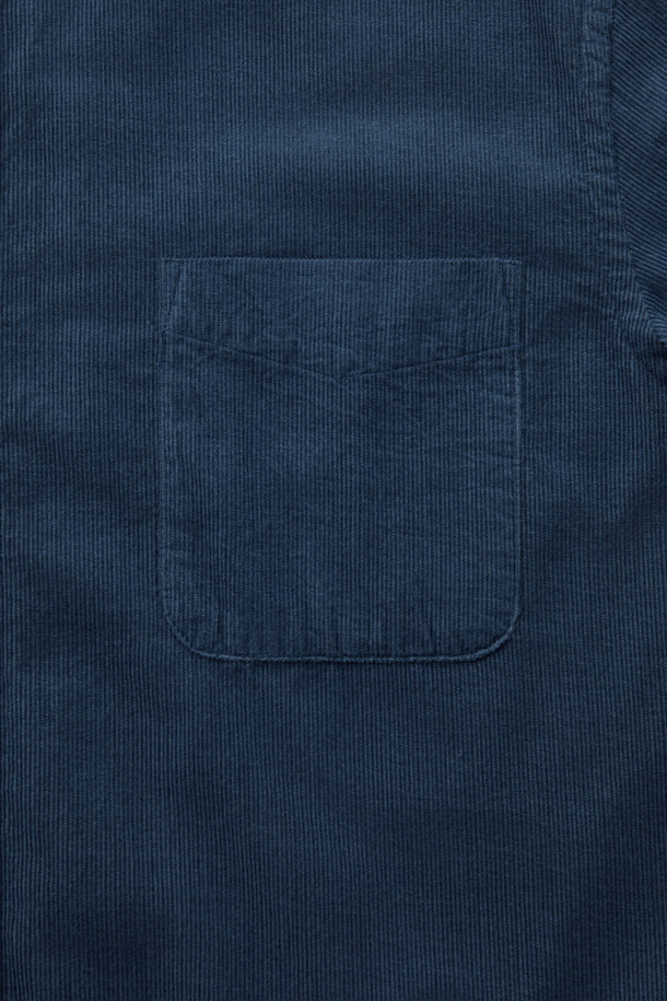 터키 KIPAS사의 수입 코듀로이 원단을 사용한 [Imported Fabric] 코듀로이 솔리드 셔츠 (컴포트핏)입니다. 톤온톤 네이비 컬러의 투톤 배색이 특징이며, 버튼다운 카라 디자인으로 클래식한 분위기를 연출합니다. 가슴 포켓과 뒷면 요크 주름 디테일이 돋보이며, 헨리코튼 라벨로 고급스러움을 더했습니다. 겨울철 비즈니스 캐주얼 및 데일리룩에 활용하기 좋은 긴소매 셔츠입니다. 컴포트핏으로 편안한 착용감을 선사합니다.
