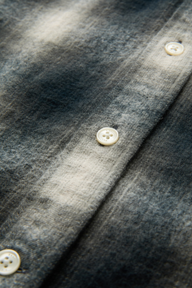 [imported Fabric] 블랙 옴브레 체크 셔츠 (컴포트핏)는 일본 SUNWELL사의 원단을 사용하여 제작된 캐주얼 셔츠입니다. 면 100% 트윌 기모 소재로 부드러운 촉감과 보온성을 제공하며, 겨울철 데일리룩에 적합합니다. 블랙, 아이보리, 그레이 세 가지 색상으로 출시되었으며, 옴브레 체크 패턴이 빈티지한 무드를 더합니다. 가슴 포켓과 뒷면 요크 주름 디테일, 헨리코튼 라벨이 특징이며, 컴포트핏으로 편안하게 착용 가능합니다. 착용 시기는 11월부터 2월까지입니다.
