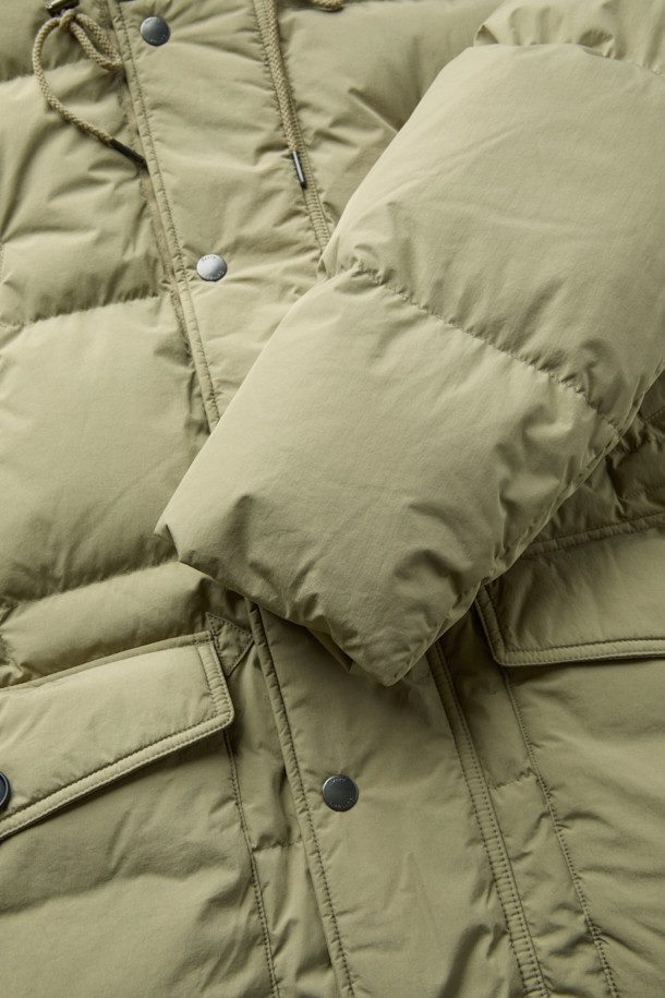 쌀쌀한 겨울 날씨에도 따뜻함을 선사할 사파리 후디 다운 점퍼입니다. 베이지 색상의 세미 오버핏으로 밀리터리 무드와 모던함을 동시에 느낄 수 있습니다. 방풍 기능과 보온성을 갖춘 두꺼운 두께감의 나일론 소재로 제작되었으며, 후드 스트링, 가슴 및 사이드 아웃 포켓 디테일로 실용성을 더했습니다. 허리 스트링 조절, 후드 버클 비죠, 이너 커프스 엘라스틱 밴드, 머스코비 다운 충전재를 통해 더욱 꼼꼼하게 보온성을 높였습니다. 겨울 데일리룩, 산책룩, 여행룩 등 다양한 TPO에 캐주얼, 미니멀, 클래식 무드로 연출하기 좋습니다.
