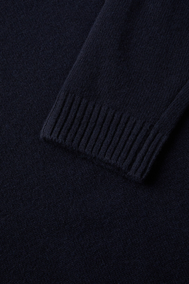 (기획) 솔리드 라운드 니트는 메리노 울 100% 소재로 제작되어 부드러운 촉감과 뛰어난 보온성을 제공합니다. 네이비 컬러에 가슴 로고 자수가 포인트로 더해져 미니멀하면서도 클래식한 분위기를 연출합니다. 라운드넥 디자인과 레귤러핏으로 제작되어 오피스룩, 비즈니스 캐주얼 등 다양한 TPO에 활용하기 좋습니다. 립 마감 처리로 깔끔함을 더했으며, 고급스러운 광택감이 돋보입니다. 가을, 겨울 시즌 데일리 아이템으로 활용하기 좋은 베이직 니트입니다.
