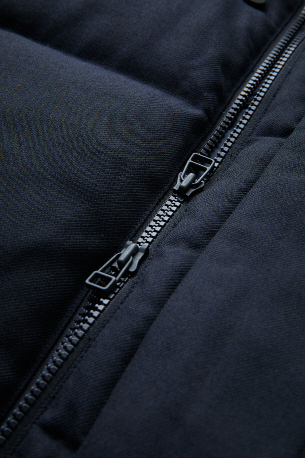 FFC x DOCUMENT (FFC x 도큐먼트) 울 헤비 다운 파카는 겨울철 데일리룩을 위한 클래식하고 미니멀한 스타일을 제안합니다. 부드러운 촉감의 울 소재로 제작되었으며, 두꺼운 두께감으로 뛰어난 보온성을 자랑합니다. 라글란 소매와 암홀 패널 설계를 통해 편안한 착용감을 제공하며, YKK 투웨이 지퍼, 허리 및 밑단 스트링, 내장형 후드 등의 디테일로 기능성을 더했습니다. 블랙 컬러의 무지 디자인으로 어떤 스타일에도 쉽게 매치할 수 있는 실용적인 다운 파카입니다.
