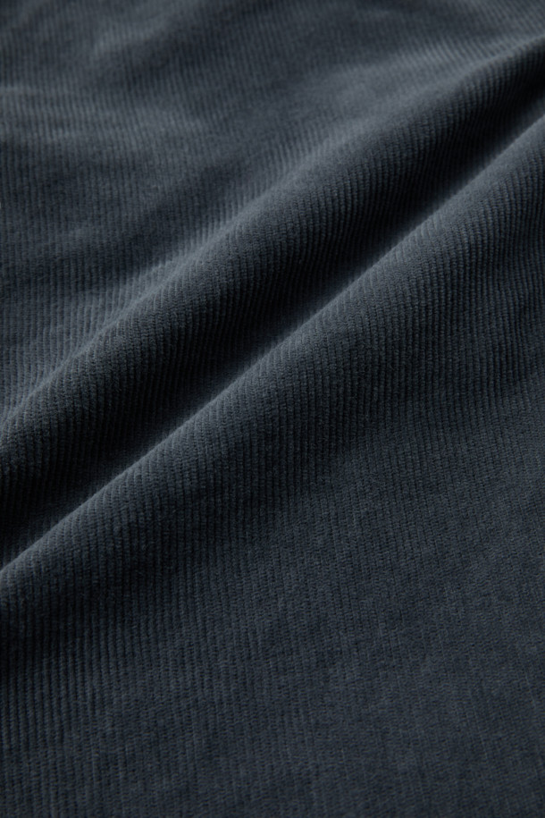 부드러운 코듀로이 소재로 제작되어 편안한 착용감을 선사하는 '코듀로이 다잉 테이퍼드 팬츠'입니다. 가먼트 다잉 기법을 적용하여 은은한 네이비 컬러를 연출하며, 캐주얼 및 클래식 스타일을 모두 소화할 수 있습니다. 쌀쌀한 가을, 겨울철에 따뜻하게 입을 수 있으며, 출근룩이나 모임룩으로 활용하기 좋습니다. 양 사이드 포켓과 뒷 포켓 디테일은 실용성을 더하고, 헨리코튼 라벨로 포인트를 주었습니다. 테이퍼드 핏으로 다리가 길어 보이는 효과를 줍니다.
