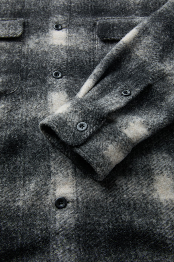 이태리 Mapel(마펠)사 수입 원단을 사용한 울 체크 아우터형 셔츠입니다. 부드러운 촉감의 울, 폴리에스터, 아크릴 혼방 소재로 제작되어 겨울, 초겨울 시즌에 따뜻하게 착용할 수 있습니다. 넉넉한 루즈핏으로 편안함을 더했으며, 화이트, 블랙 두 가지 색상으로 만나볼 수 있습니다. 가슴 포켓과 옆선 트임, 헨리코튼 포인트 라벨 디테일이 돋보이는 캐주얼 스타일의 긴소매 셔츠입니다. 두꺼운 두께감과 기모 안감으로 보온성을 높였습니다.
