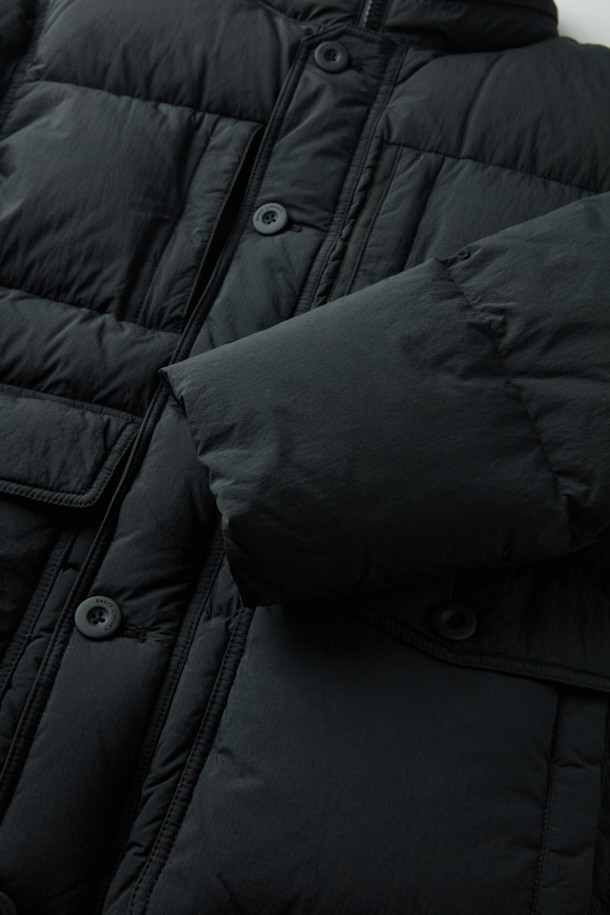 세미 오버핏으로 편안하게 착용 가능한 퀼팅 다운 점퍼입니다. 겨울철 추위를 막아주는 두꺼운 두께감과 보온 및 방풍 기능으로 따뜻함을 제공합니다. 부드러운 촉감의 나일론 소재와 블랙 컬러의 무지 디자인으로 캐주얼, 미니멀, 클래식 등 다양한 스타일 연출에 활용할 수 있습니다. 멀티 포켓, 지퍼 테이프 부분 노출, 밑단 스트링, 내장 후드, 벨보아 넥 안감, 이너 커프스 엘라스틱 밴드, 머스코비 다운 충전재 등 디테일이 돋보입니다. 출근룩, 여행룩 등 일상에서 폭넓게 활용 가능하며, 긴 소매와 지퍼형 여밈 방식으로 편의성을 더했습니다.
