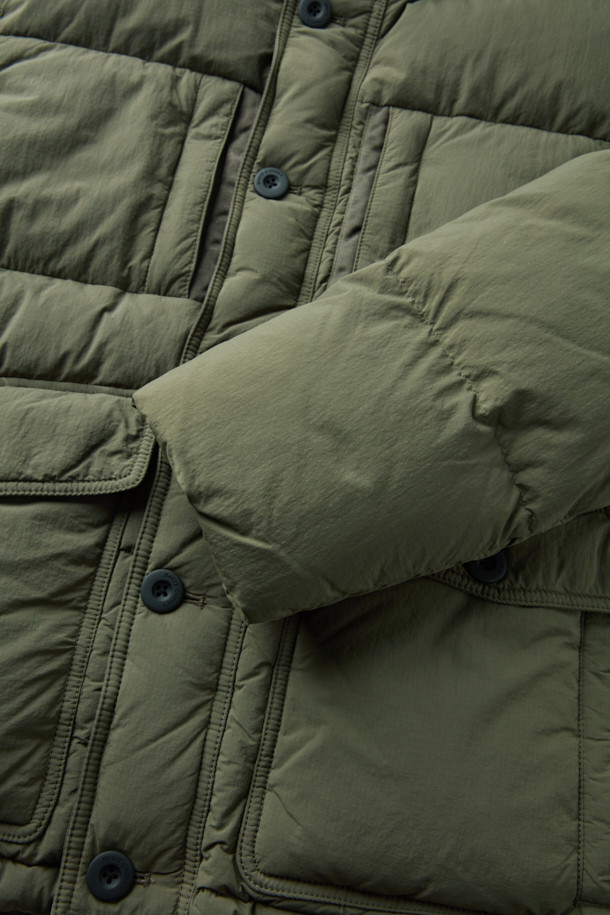 **퀼팅 다운 점퍼**

쌀쌀한 겨울 날씨에도 따뜻함과 스타일을 놓치지 않도록 퀼팅 디자인의 다운 점퍼를 소개합니다. 카키와 올리브 두 가지 색상으로 출시되어, 캐주얼, 미니멀, 시티보이 룩을 연출하기 좋습니다. 부드러운 나일론 소재와 두꺼운 두께감으로 보온성과 방풍 기능을 제공하며, 세미 오버핏으로 편안하게 착용 가능합니다. 멀티 포켓, 지퍼 테이프 노출, 밑단 스트링, 후드 내장, 벨보아 넥 안감, 이너 커프스 엘라스틱 밴드, 머스코비 다운 충전재 등 다양한 디테일이 돋보입니다. 출근룩과 여행룩 모두에 활용할 수 있는 실용적인 아이템입니다.
