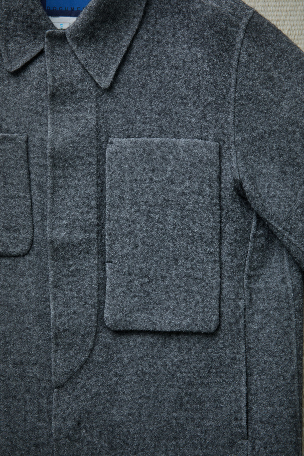 FFC x DOCUMENT(에프에프씨 x 도큐먼트)의 울 핸드메이드 필드 셔팅 재킷입니다. 이탈리아 엠티티사의 멜란지 보일드 울 소재를 사용하여 부드러운 촉감과 두꺼운 두께로 따뜻함을 제공합니다. 미니멀하고 클래식한 디자인에 플라이 피싱웨어 디테일을 더했으며, 핸드메이드 공법으로 제작되어 높은 퀄리티를 자랑합니다. 숏 기장의 세미루즈핏으로 편안한 착용감을 선사하며, 가을, 겨울철 데일리룩과 가을 나들이룩에 활용하기 좋습니다. 실용적인 포켓 디테일과 버튼 여밈 방식으로 제작된 그레이 컬러의 무지 재킷입니다.