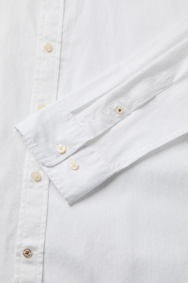 가을 잔조직 셔츠는 베이직한 스타일의 면 셔츠입니다. 화이트 컬러의 레귤러핏으로, 출근룩, 비즈니스 캐주얼, 오피스룩 등 다양한 TPO에 적합합니다. 긴 소매와 버튼다운 네크라인 디자인이 특징이며, 가슴 부분의 로고 자수 디테일이 돋보입니다. 은은한 조직감과 뒷면 요크 주름으로 세련된 실루엣을 연출하며, 클래식, 미니멀, 캐주얼 스타일을 모두 소화할 수 있습니다.
