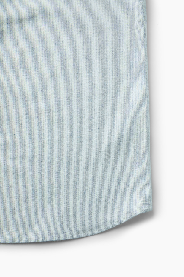 **핀 스트라이프 셔츠 (레귤러핏)**

부드러운 면 기모 옥스포드 원단으로 제작된 핀 스트라이프 셔츠입니다. 화이트와 블루 두 가지 색상으로 출시되었으며, 베이직한 디자인으로 비즈니스 캐주얼 및 일상 룩에 활용하기 좋습니다. 레귤러핏으로 편안한 착용감을 선사하며, 버튼다운 네크라인과 긴 소매 기장이 특징입니다. 가슴 부분에는 로고 자수, 뒷면에는 요크 주름 디테일이 더해져 고급스러운 분위기를 연출합니다. 겨울철 출근룩에 클래식하고 미니멀한 스타일을 더해보세요.
