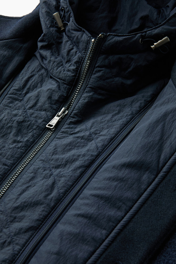 이탈리안 원단으로 제작된 탈착 가능한 후드 울 다운 점퍼입니다. 네이비 컬러의 베이직한 디자인으로, 겨울철 일상, 산책, 여행 등 다양한 TPO에 활용하기 좋습니다. 부드러운 촉감의 울 소재와 구스다운 충전재를 사용하여 보온성과 경량성을 모두 갖췄습니다. 탈착 가능한 후드와 퀼팅 디테일, 울 펠트 배색이 특징이며, 사이드 포켓으로 실용성을 더했습니다. 베이직핏으로 클래식, 미니멀, 캐주얼 스타일을 연출하기에 용이합니다.
