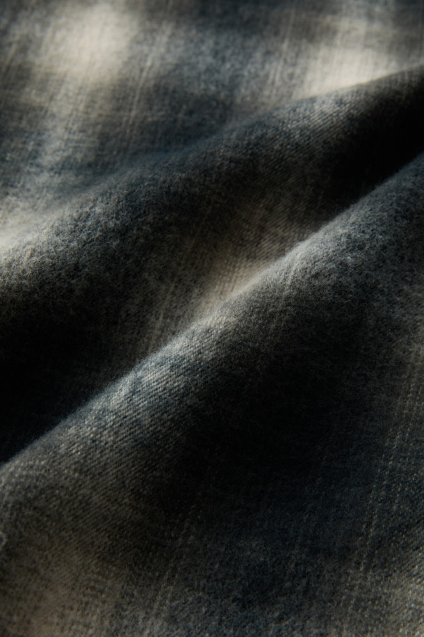 [imported Fabric] 블랙 옴브레 체크 셔츠 (컴포트핏)는 일본 SUNWELL사의 원단을 사용하여 제작된 캐주얼 셔츠입니다. 면 100% 트윌 기모 소재로 부드러운 촉감과 보온성을 제공하며, 겨울철 데일리룩에 적합합니다. 블랙, 아이보리, 그레이 세 가지 색상으로 출시되었으며, 옴브레 체크 패턴이 빈티지한 무드를 더합니다. 가슴 포켓과 뒷면 요크 주름 디테일, 헨리코튼 라벨이 특징이며, 컴포트핏으로 편안하게 착용 가능합니다. 착용 시기는 11월부터 2월까지입니다.
