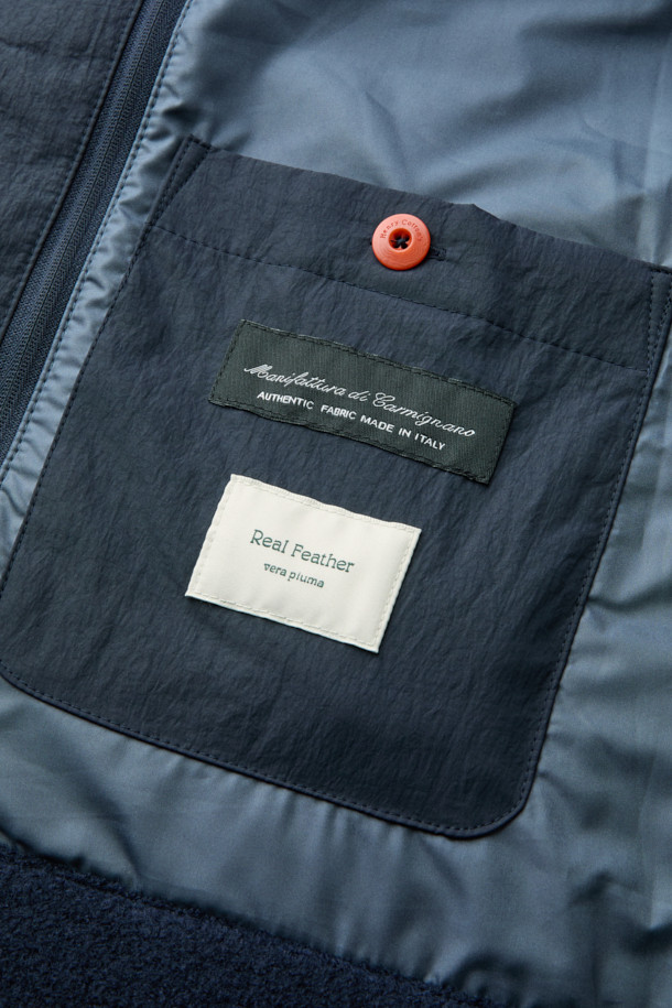 이탈리안 원단으로 제작된 탈착 가능한 후드 울 다운 점퍼입니다. 네이비 컬러의 베이직한 디자인으로, 겨울철 일상, 산책, 여행 등 다양한 TPO에 활용하기 좋습니다. 부드러운 촉감의 울 소재와 구스다운 충전재를 사용하여 보온성과 경량성을 모두 갖췄습니다. 탈착 가능한 후드와 퀼팅 디테일, 울 펠트 배색이 특징이며, 사이드 포켓으로 실용성을 더했습니다. 베이직핏으로 클래식, 미니멀, 캐주얼 스타일을 연출하기에 용이합니다.
