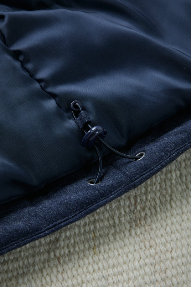 FFC x DOCUMENT(FFC x 도큐먼트) 테크니컬 울 구스다운 파카는 겨울철 데일리룩을 위한 클래식하고 미니멀한 스타일의 아우터입니다. 네이비 컬러의 무지 디자인으로, 울 소재 특유의 부드러운 촉감과 두꺼운 두께감이 특징입니다. 90/10 구스다운 충전재, 라글란 소매, 조절 가능한 스트링, 이중 포켓, 암홀 무 패치 디자인 등 디테일한 요소들이 돋보입니다. 보온, 방풍, 투습 기능을 갖춰 추운 날씨에도 쾌적하게 착용할 수 있습니다. 집업 방식으로 편안하게 여밀 수 있으며, 루즈핏으로 편안한 착용감을 선사합니다.
