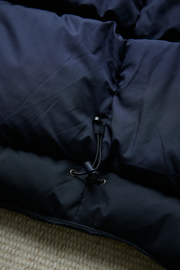 FFC x DOCUMENT (FFC x 도큐먼트) 피셔맨 셔팅 구스 다운 재킷은 겨울철 데일리룩을 위한 미니멀하고 클래식한 스타일의 아우터입니다. 블랙 컬러에 무지 디자인으로 어떤 옷에도 쉽게 매치할 수 있으며, 셔츠형 코트 타입으로 세련된 느낌을 더했습니다. 90/10 구스다운 충전재와 경량 소재를 사용하여 보온성과 편안한 착용감을 제공하며, 루즈핏으로 여유로운 실루엣을 연출합니다. 입체 포켓과 여유있는 어깨라인이 특징이며, 투웨이 지퍼 여밈 방식으로 실용성을 높였습니다.
