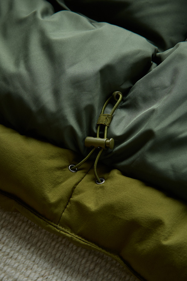 FFC x DOCUMENT (FFC x 도큐먼트) 피셔맨 셔팅 구스 다운 재킷은 겨울철 데일리룩에 적합한 미니멀하면서도 캐주얼한 스타일의 아우터입니다. 올리브 및 카키 색상으로 출시되었으며, 가볍고 따뜻한 구스다운 90/10 충전재를 사용하여 보온성과 경량성을 동시에 잡았습니다. 셔츠형 디자인에 투웨이 지퍼 여밈 방식과 입체 포켓 디테일을 더해 실용성을 높였으며, 여유 있는 어깨 라인과 루즈핏으로 편안한 착용감을 선사합니다. 부드러운 촉감의 나일론 소재로 제작되었으며, 긴 소매 기장과 두꺼운 두께감으로 추운 겨울에도 따뜻하게 입을 수 있습니다.
