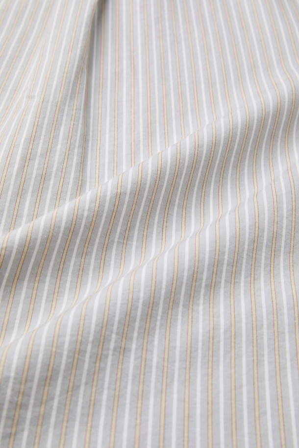 베이지 스트라이프 셔츠 (레귤러핏)는 비즈니스 캐주얼, 출근룩, 모임룩에 적합한 남성 셔츠입니다. 베이지, 화이트, 그레이 세 가지 색상으로 구성되어 있으며, 가을에 어울리는 긴 소매 디자인입니다. 면 소재로 제작되어 탄탄한 촉감을 자랑하며, 레귤러핏으로 편안한 착용감을 선사합니다. 가슴 로고 자수, 뒷면 요크 주름, 트윌 조직 디테일이 돋보이며, 베이직하고 캐주얼한 스타일을 연출합니다. 버튼다운 카라와 스트라이프 패턴이 세련된 느낌을 더합니다.
