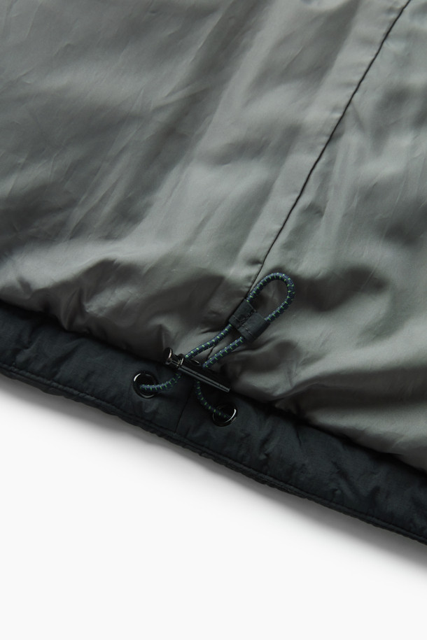 세미 오버핏으로 편안하게 착용 가능한 퀼팅 다운 점퍼입니다. 겨울철 추위를 막아주는 두꺼운 두께감과 보온 및 방풍 기능으로 따뜻함을 제공합니다. 부드러운 촉감의 나일론 소재와 블랙 컬러의 무지 디자인으로 캐주얼, 미니멀, 클래식 등 다양한 스타일 연출에 활용할 수 있습니다. 멀티 포켓, 지퍼 테이프 부분 노출, 밑단 스트링, 내장 후드, 벨보아 넥 안감, 이너 커프스 엘라스틱 밴드, 머스코비 다운 충전재 등 디테일이 돋보입니다. 출근룩, 여행룩 등 일상에서 폭넓게 활용 가능하며, 긴 소매와 지퍼형 여밈 방식으로 편의성을 더했습니다.
