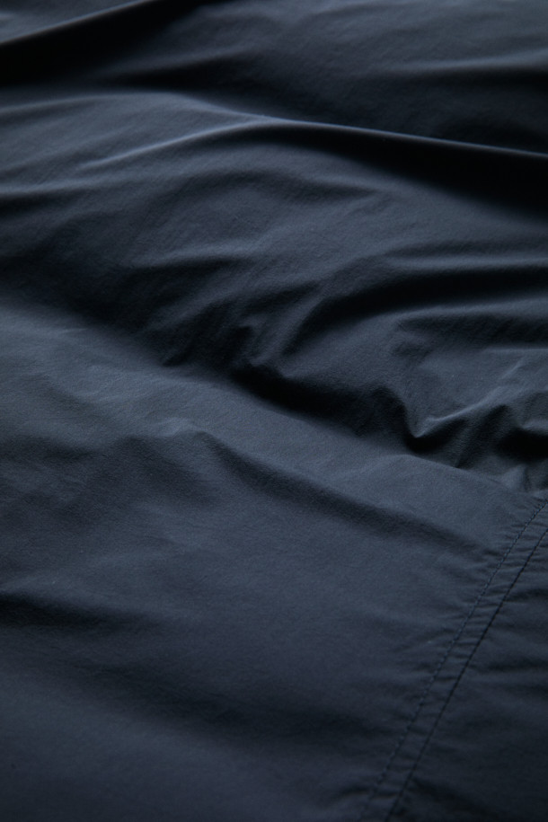 FFC x DOCUMENT (FFC x 도큐먼트) 피셔맨 셔팅 구스 다운 재킷은 겨울철 데일리룩을 위한 미니멀하고 클래식한 스타일의 아우터입니다. 블랙 컬러에 무지 디자인으로 어떤 옷에도 쉽게 매치할 수 있으며, 셔츠형 코트 타입으로 세련된 느낌을 더했습니다. 90/10 구스다운 충전재와 경량 소재를 사용하여 보온성과 편안한 착용감을 제공하며, 루즈핏으로 여유로운 실루엣을 연출합니다. 입체 포켓과 여유있는 어깨라인이 특징이며, 투웨이 지퍼 여밈 방식으로 실용성을 높였습니다.
