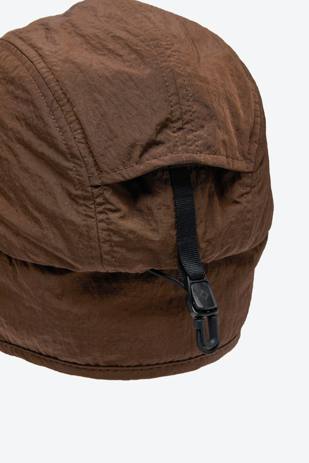 보온성과 방풍 기능을 갖춘 트루퍼 캡입니다. 겨울철 추위로부터 보호해주는 두꺼운 두께감과 부드러운 촉감의 나일론 소재를 사용하여 편안한 착용감을 선사합니다. 40g/m² 저중량 합성 패딩 충전재와 기모, 패딩 안감으로 보온성을 높였으며, 귀 전체를 덮는 이어플랩 구조로 찬 바람을 효과적으로 막아줍니다. 후면 조절 스트링과 스토퍼가 있어 사이즈 조절이 용이하며, 일상 및 아웃도어 활동 시 캐주얼, 고프코어 및 워크웨어 스타일과 함께 매치하여 따뜻하고 스타일리시한 겨울 룩을 연출할 수 있습니다. 무지 디자인의 브라운 컬러로 다양한 코디에 활용하기 좋습니다.