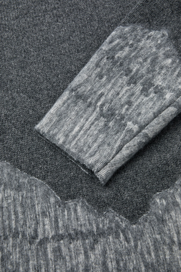 다크 그레이와 라이트 그레이 투톤 컬러 배색이 돋보이는 울 혼방 니트입니다. 울 82%와 나일론 18% 혼방으로 제작되어 부드러운 촉감과 뛰어난 보온성을 자랑하며, 통기성과 소취 기능까지 갖춰 겨울철에도 쾌적하게 착용할 수 있습니다. 라운드넥과 레귤러핏 디자인으로, 일상복은 물론 캠핑룩, 출근룩 등 다양한 TPO에 활용 가능하며, 캐주얼, 클래식, 미니멀 스타일을 모두 소화합니다. 긴 소매 기장의 두꺼운 두께감으로 추운 날씨에도 따뜻하게 몸을 감싸줍니다. 데일리 니트웨어이자 이너와 아우터 모두 활용 가능한 실용적인 아이템입니다.
