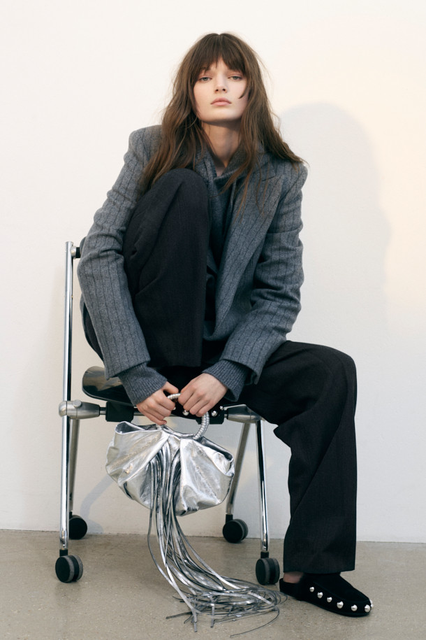 NIMI 클래식 울 블레이저는 여성 고객을 위한 가을, 겨울용 아우터입니다. 클래식한 스타일의 그레이 컬러 핀스트라이프 패턴이 특징이며, 오피스룩, 출근룩, 모임룩에 적합합니다. 두꺼운 울 혼방 소재로 제작되어 보온성을 높였으며, 스트레이트 핏과 싱글 버튼 여밈 방식으로 세련된 실루엣을 연출합니다. 피크드 라펠과 플랩 포켓 디테일이 돋보이며, 레이온과 면 안감으로 편안한 착용감을 선사합니다.
