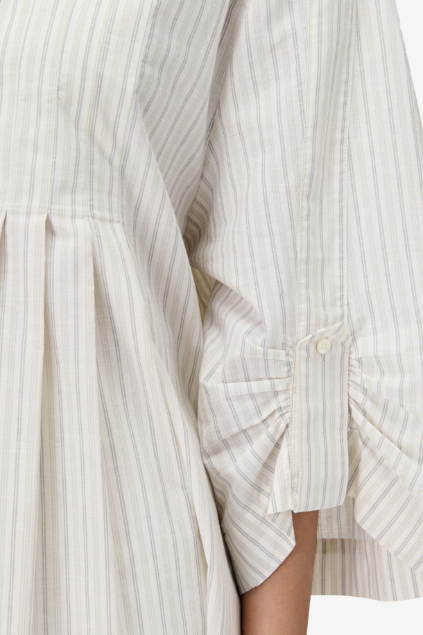 TULIA(튤리아) 스트라이프 셔츠 드레스는 밴드 칼라 디자인으로 깔끔한 핏을 연출하며, 봄, 여름 시즌 일상룩과 데이트룩, 봄 소풍룩에 적합합니다. 루즈핏으로 편안함을 더하고, 허리 플리츠 디테일이 여성스러운 실루엣을 만들어줍니다. 긴소매와 와이드 소매 디자인이 특징이며, 캐주얼, 미니멀, 클래식 스타일을 모두 소화할 수 있습니다. 면 소재의 스트라이프 패턴 셔츠 원피스로, 버튼다운 클로징과 탭 디테일이 포인트를 더합니다.
