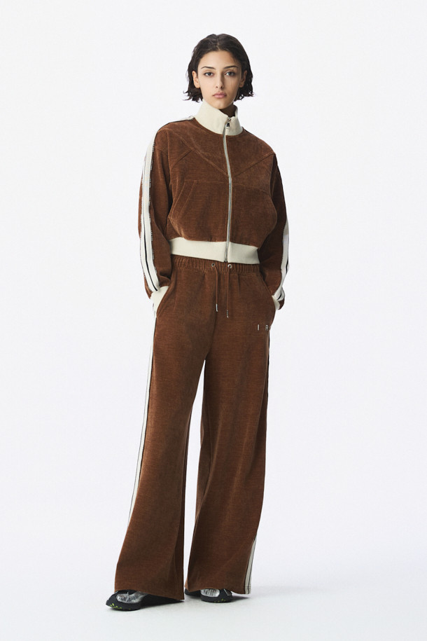 TRILLO 2.0 트랙 팬츠는 편안하고 스타일리시한 일상 및 스포츠 활동에 적합한 바지입니다. 브라운 컬러의 루즈핏 긴바지로, 봄, 여름에 특히 활용하기 좋습니다. 폴리에스터와 폴리우레탄 혼방 소재로 제작되어 부드러운 촉감을 선사합니다. 허리에는 드로스트링 밴딩이 있어 편안한 착용감을 제공하며, 사이드 로고 테이프가 스포티하고 캐주얼한 스타일을 더합니다. 넉넉한 실루엣으로 활동성을 높인 트랙 팬츠입니다.
