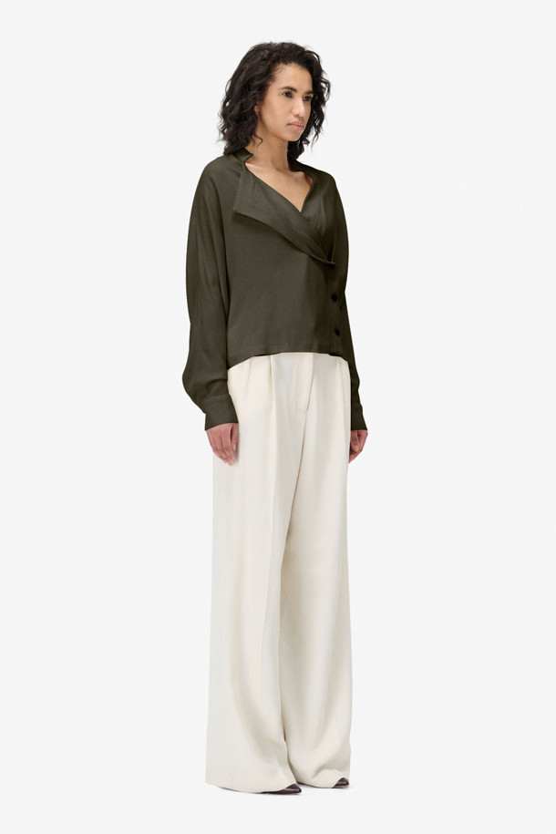 PAQUITA(파키타) 프론트 랩 버튼 블라우스는 여성스러운 실루엣을 연출하는 블라우스입니다. 카키와 화이트 두 가지 색상으로 출시되었으며, 봄, 가을에 입기 좋습니다. 미니멀한 스타일로, 데이트룩, 오피스룩, 모임룩 등 다양한 TPO에 활용 가능합니다. 스탠드 칼라와 긴소매, 레귤러핏으로 디자인되었으며, 비대칭 버튼 여밈과 랩 스타일, 측면 버튼 클로징, 뒷면 허리 밴딩 디테일이 특징입니다. 레이온과 모 혼방 소재로 제작되어 부드러운 촉감을 선사하며, 셋업으로도 연출할 수 있습니다.
