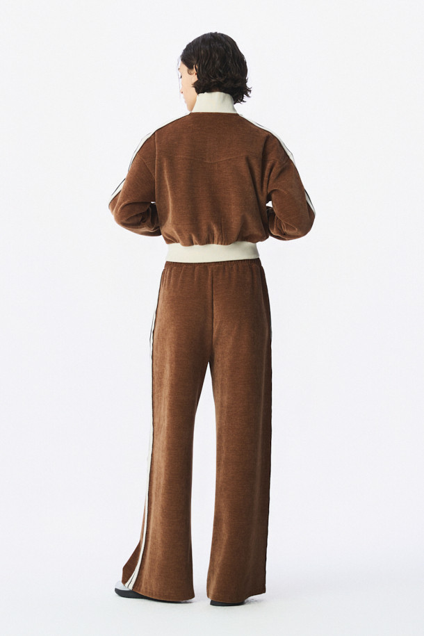 TRILLA 2.0 트랙 재킷은 여성용 아우터로, 봄/가을 계절에 활용하기 좋은 얇은 두께의 블루종 스타일 트랙 재킷입니다. 브라운 컬러에 하이넥 디자인과 옆선 로고 테이핑 디테일이 스포티하면서도 캐주얼한 무드를 연출합니다. 레귤러핏으로 제작되었으며, 집업 방식으로 간편하게 착용할 수 있습니다. 일상, 산책, 여행 등 다양한 TPO에 스타일리시하게 매치하여 캐주얼, 스포티, 미니멀 스타일을 완성할 수 있습니다. 긴 소매 기장의 폴리에스테르와 폴리우레탄 혼방 소재로 제작되었습니다.
