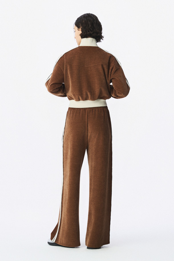 TRILLO 2.0 트랙 팬츠는 편안하고 스타일리시한 일상 및 스포츠 활동에 적합한 바지입니다. 브라운 컬러의 루즈핏 긴바지로, 봄, 여름에 특히 활용하기 좋습니다. 폴리에스터와 폴리우레탄 혼방 소재로 제작되어 부드러운 촉감을 선사합니다. 허리에는 드로스트링 밴딩이 있어 편안한 착용감을 제공하며, 사이드 로고 테이프가 스포티하고 캐주얼한 스타일을 더합니다. 넉넉한 실루엣으로 활동성을 높인 트랙 팬츠입니다.
