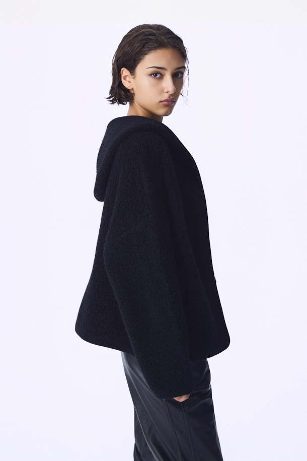 COUP DE (쿠 드) 니트 후드 재킷은 가을과 겨울, 일상에서 편안하게 착용하기 좋은 여성용 상의입니다. 부드러운 촉감의 나일론, 모, 모헤어, 폴리우레탄 혼방 소재로 제작되어 뛰어난 보온성을 제공합니다. 캐주얼, 미니멀, 클래식 스타일을 아우르며, 오버핏으로 편안하게 떨어지는 핏과 드롭숄더 디자인이 특징입니다. 블랙 색상의 무지 디자인에 후드 네크라인과 긴 소매, 바인딩 디테일을 더해 미니멀한 무드를 연출합니다. 집콕룩, 산책룩 등 다양한 TPO에 활용할 수 있는 실용적인 아이템입니다.
